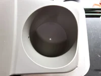 Hole in the bottom of the cupholder to secure the power socket.webp