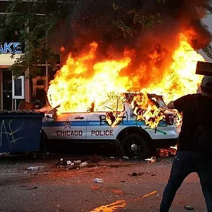 29027326-8373657-Chicago_A_Chicago_police_vehicle_is_set_on_fire_during_violent_p-a-14_159091...webp